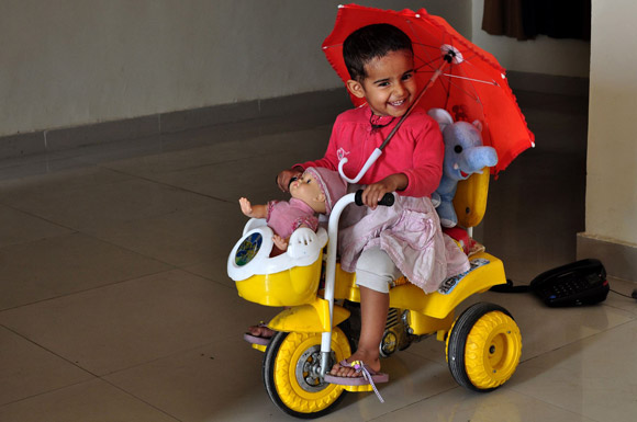 Kid cycling with her toys